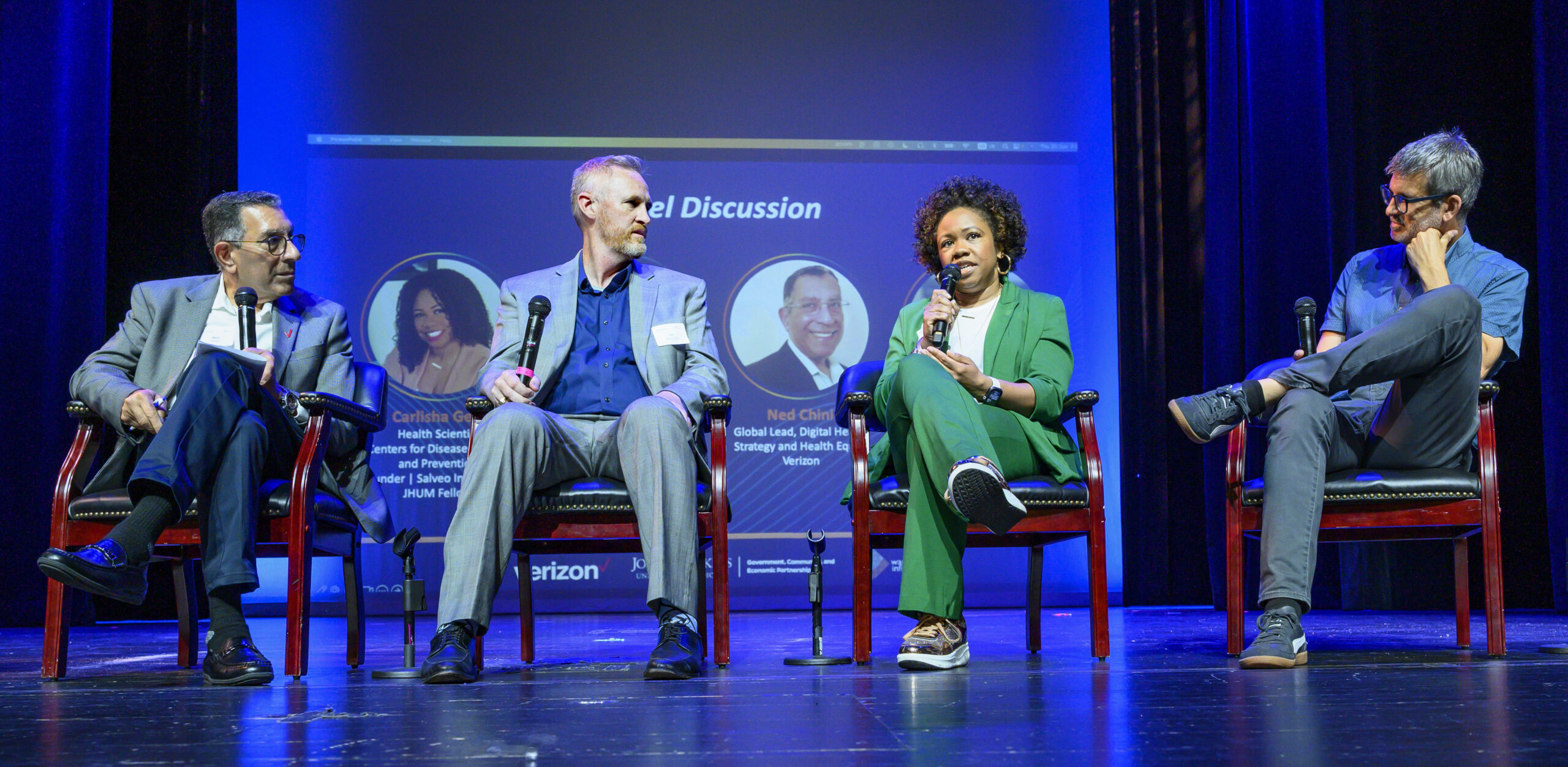 Four panelists seated on stage during discussion at Ward Infinity event