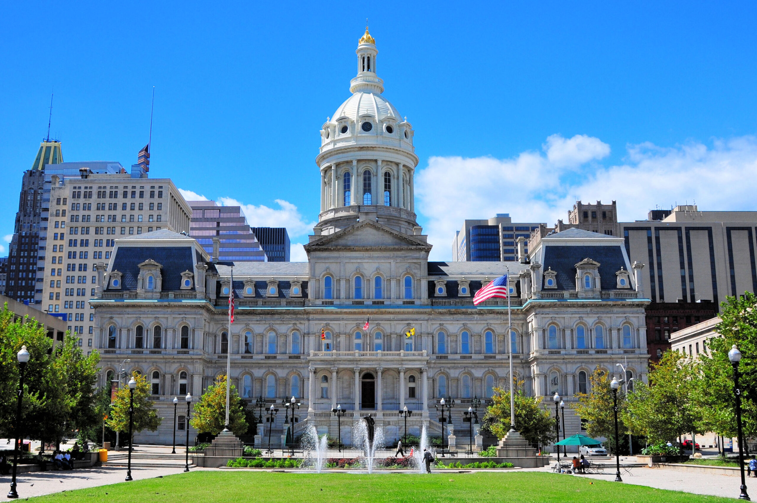 Baltimore City Hall, viewed from the front lawn with fountains and flags.