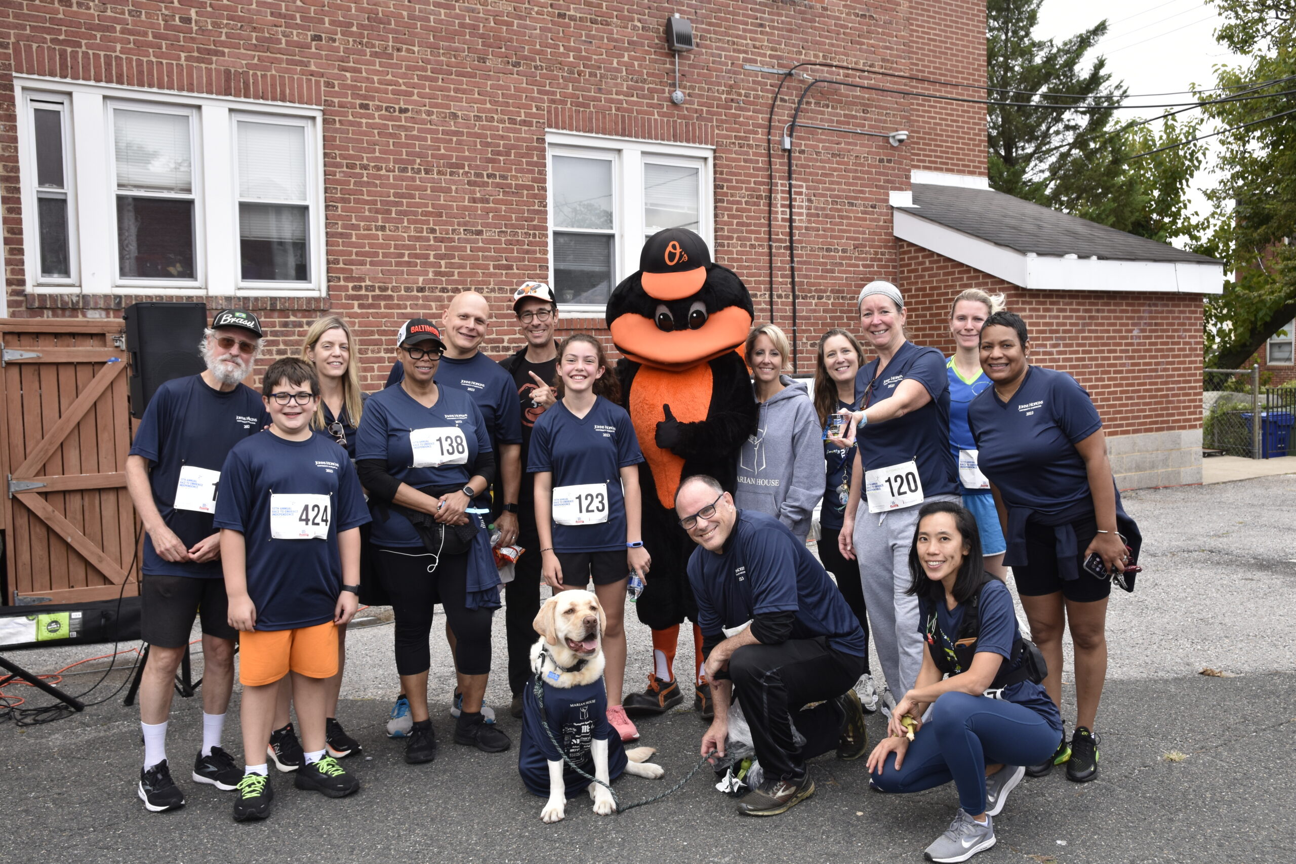 Participants in race shirts gathered at Marian House community event