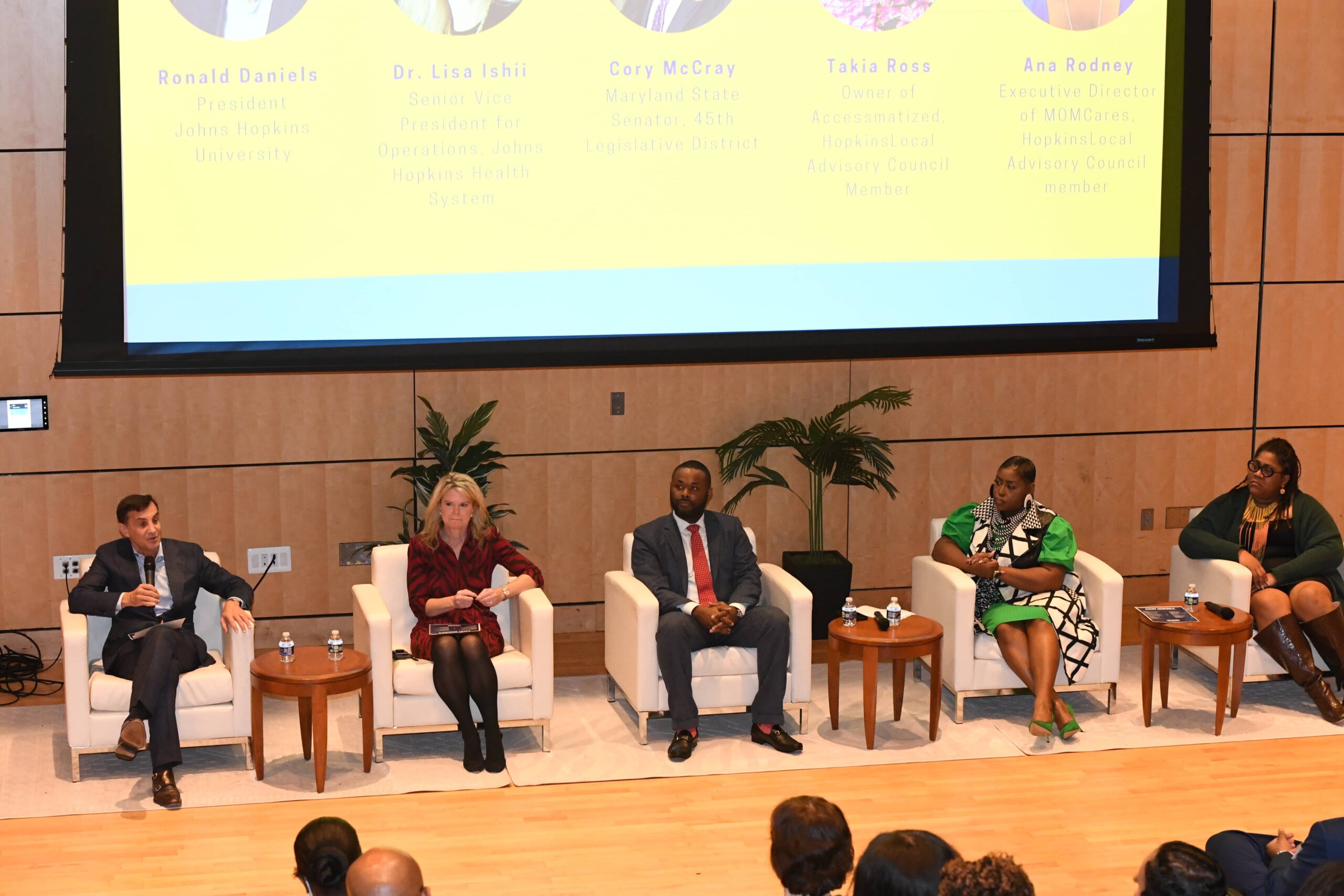 Five panelists seated on stage during a Johns Hopkins event