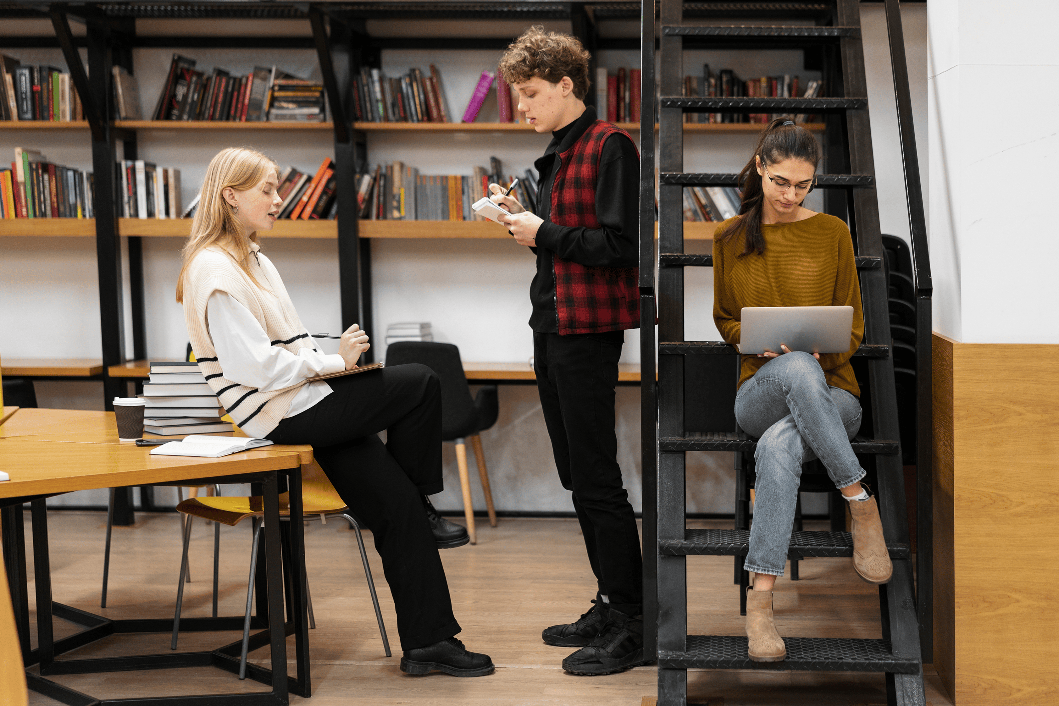 Three students in a library during individual and shared study time